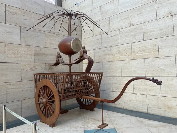 A wooden reconstruction of an ancient Chinese odometer, with a drum and two figures