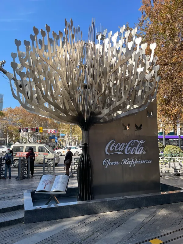 The back of the sculpture, bearing a Coca-Cola “Open Happiness” advertisement