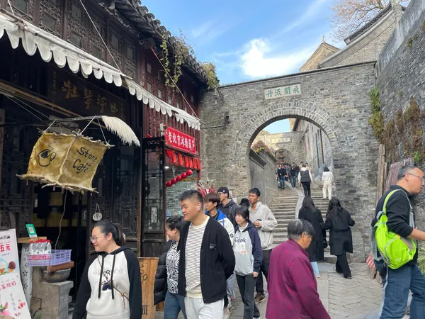 A crowded street climbing through the gates of Zhenjiang's walled town